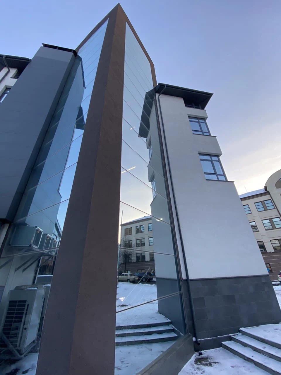 Detalle exterior donde el muro cortina se encuentra con paneles sólidos