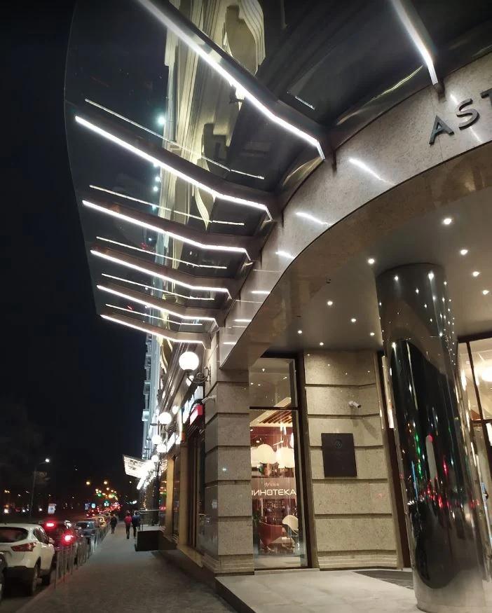 Interior comercial con techos curvos, superficies reflectantes e iluminación lineal