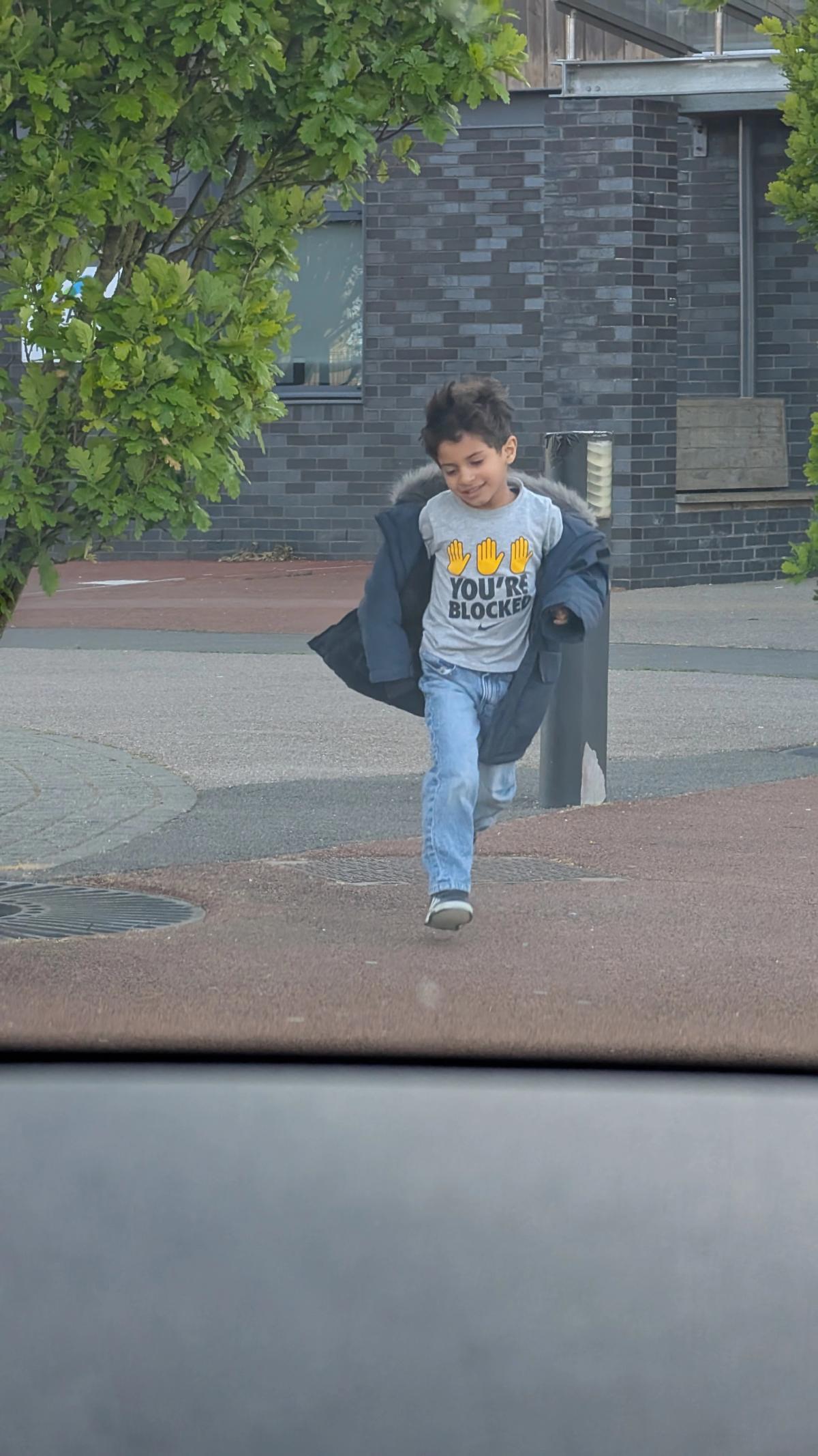 Zain playing outside while Maged watches from the car.