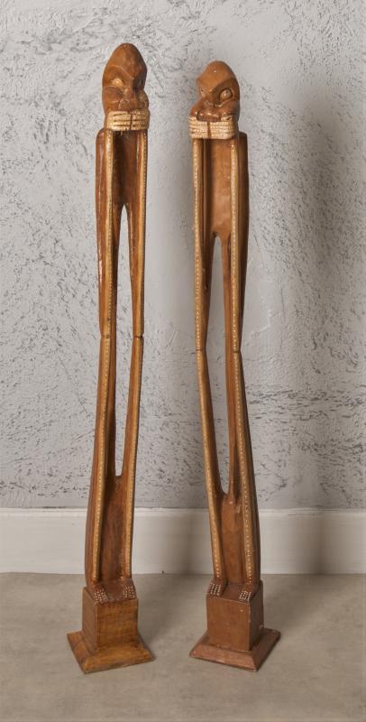 Two tall wooden decorative objects standing side by side.