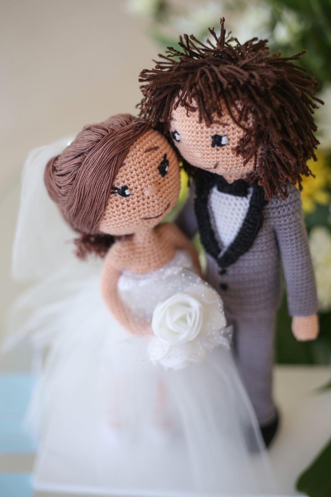 Two handmade dolls posed together, one wearing a white dress.