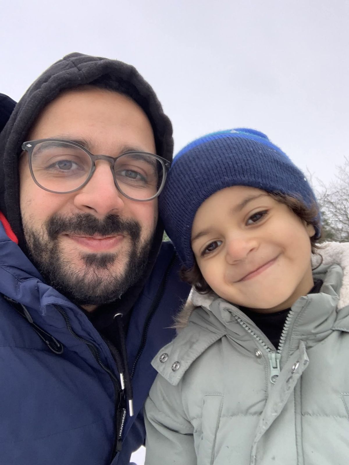 Maged and his son Zain smiling together on a winter day.
