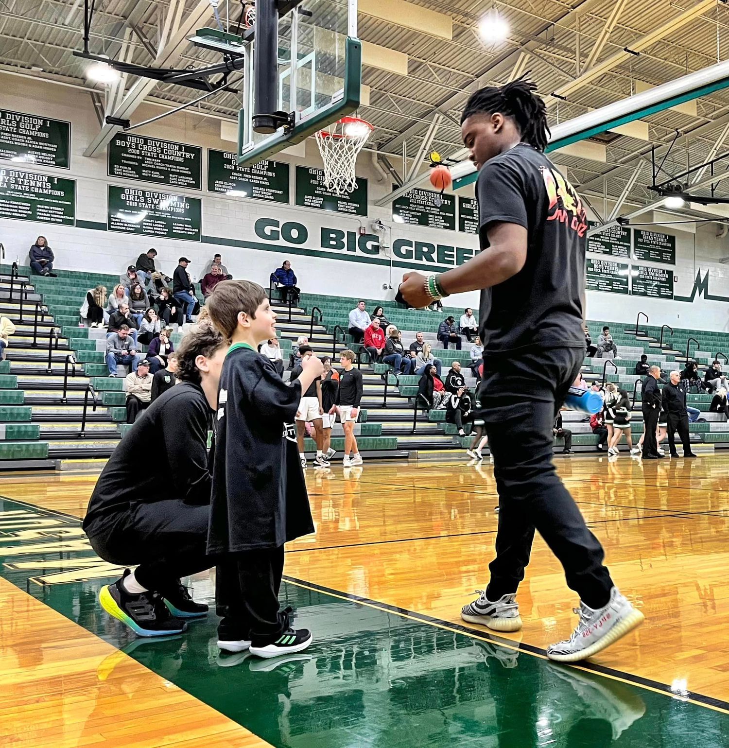 Christian on court with MHS basketball players