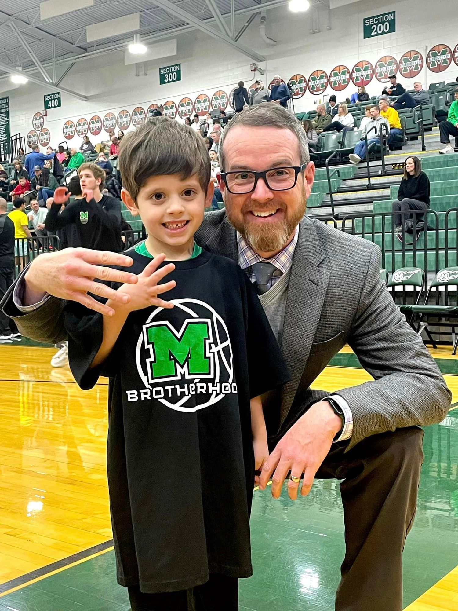 Christian posing on basketball court with Mason Schools Superintendent, Jonathan Cooper