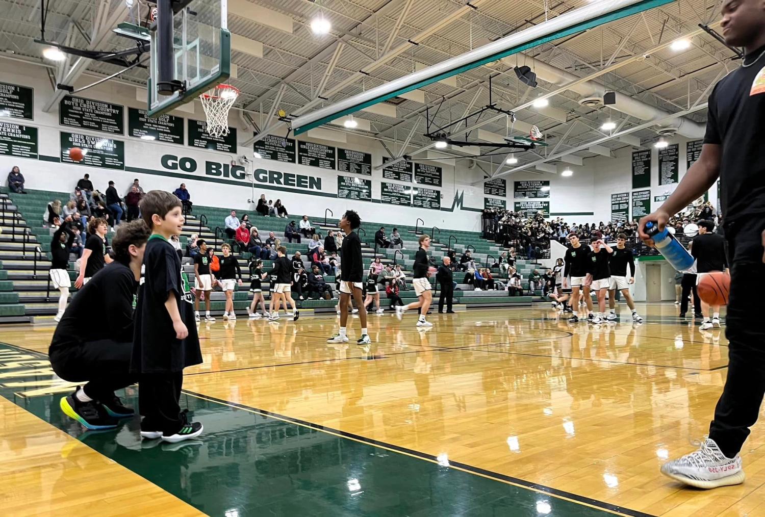 Christian on court with MHS basketball players
