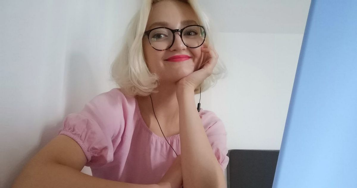a woman wearing glasses is sitting at a desk in front of a laptop computer .
