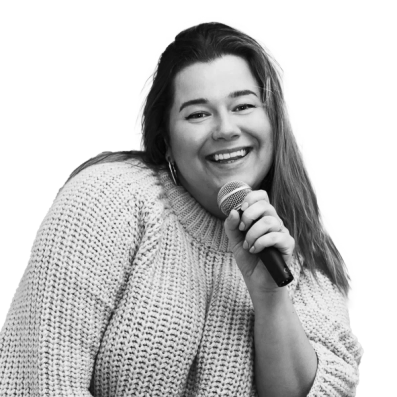 a woman in a sweater is holding a microphone and smiling
