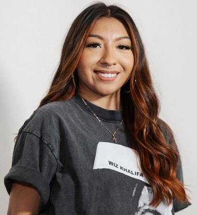 una mujer con chaqueta de cuero sostiene un vaso de vino .