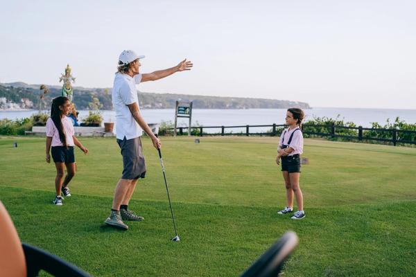 Golf teacher instructing kids