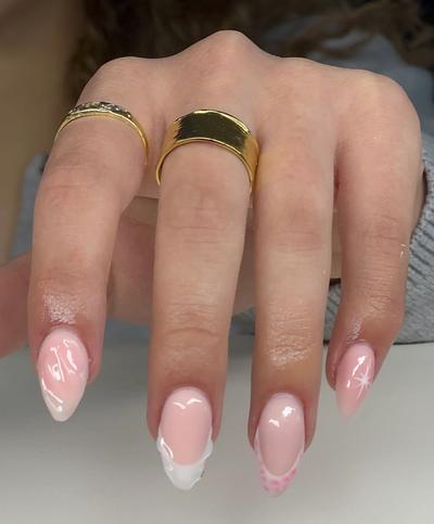 a close up of a woman 's hand with three rings on her fingers .