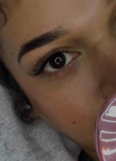 a close up of a woman 's eye with long eyelashes .