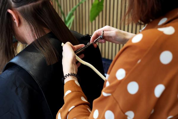 Eva knipt het haar van een klant in Amsterdam