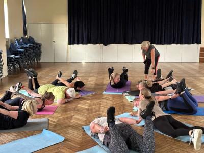 a group of women are laying on yoga mats in a gym .