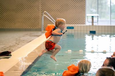 Child wearing Fibby suit jumps in the pool