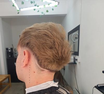 un hombre se está cortando el pelo en una barbería .