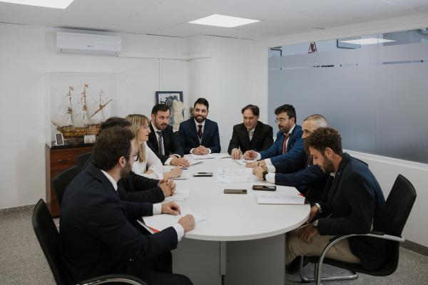 a group of people are sitting around a round table in a conference room .