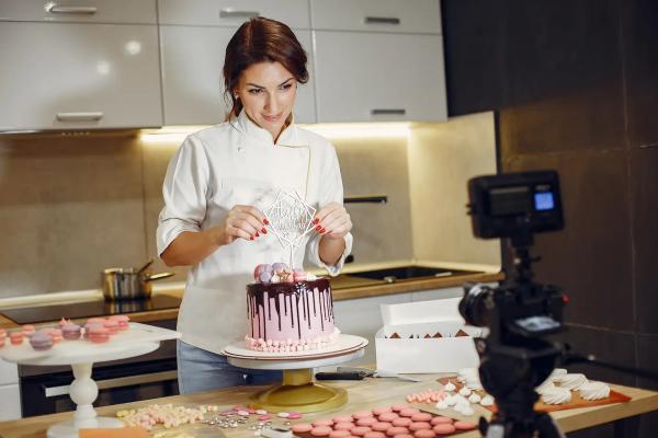 Woman taking a photo of her cake in the kitchen