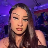 a close up of a woman 's face in a room with purple lights .