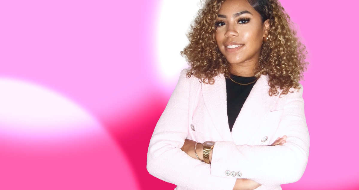 a woman in a pink jacket with her arms crossed