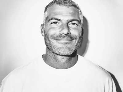 a man with a beard is smiling in a black and white photo