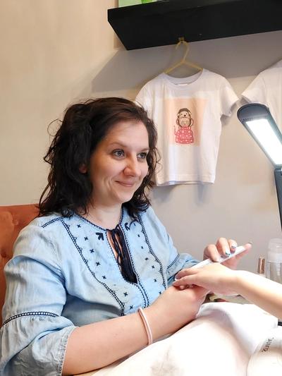 a woman is getting her nails done at a nail salon .