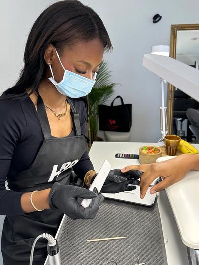 a woman wearing a mask and an apron with the letter k on it