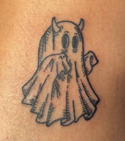 a black and white tattoo of a ghost with horns on a person 's arm.