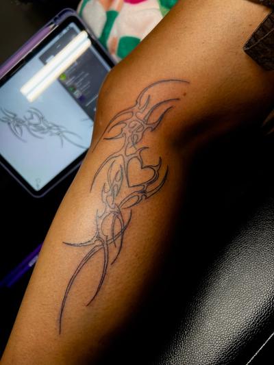 a tattoo on a person 's leg with a tablet in the background