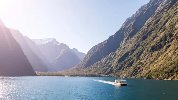 Boat cruising through Milford Sound
