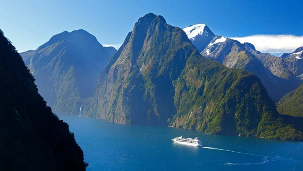 A boat cruises through Milford Sound in New Zealand