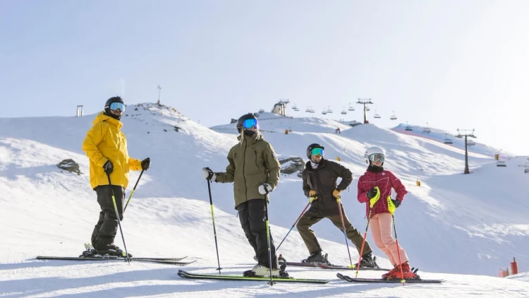 A group of 20-39 travellers on a snowy mountain in Queenstown while on a ski trip in New Zealand with Wild Kiwi.