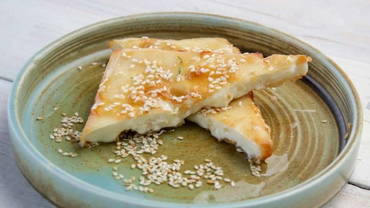 Sheep's cheese with honey and sesame seeds on a plate