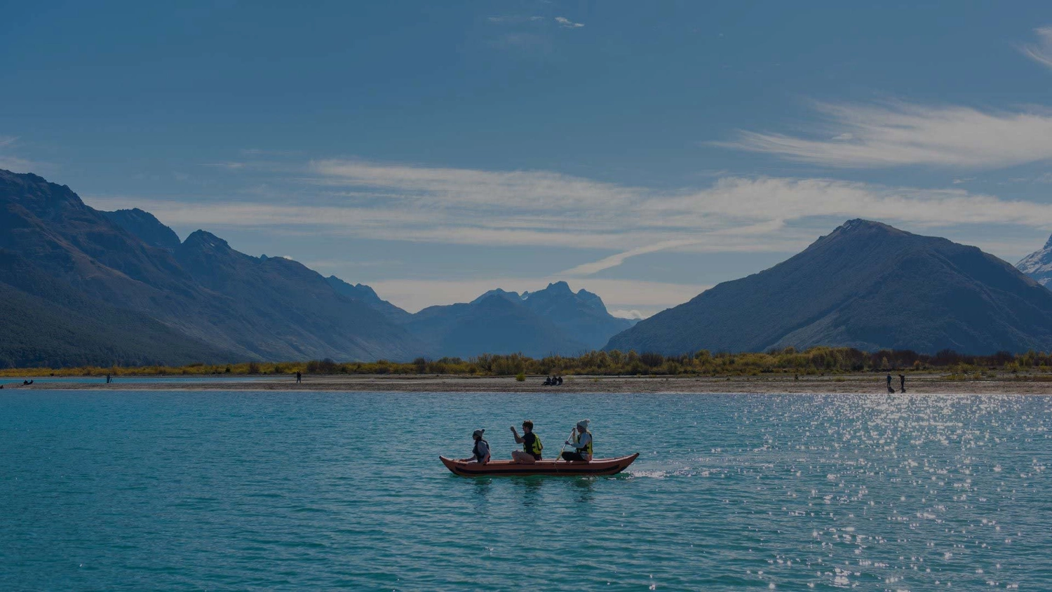 Three people on a kayak in Lake Wakatipu in New Zealand