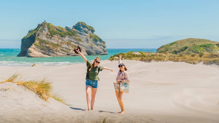 Two people on Wharariki Beach in New Zealand