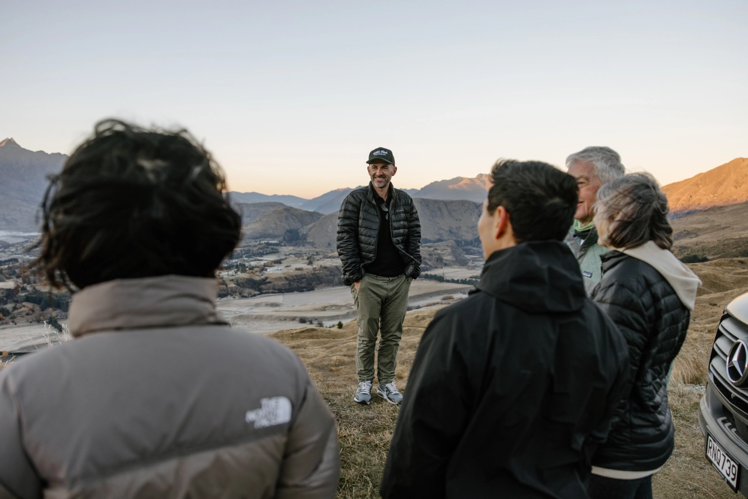 A photo of a guide with small group of people around him