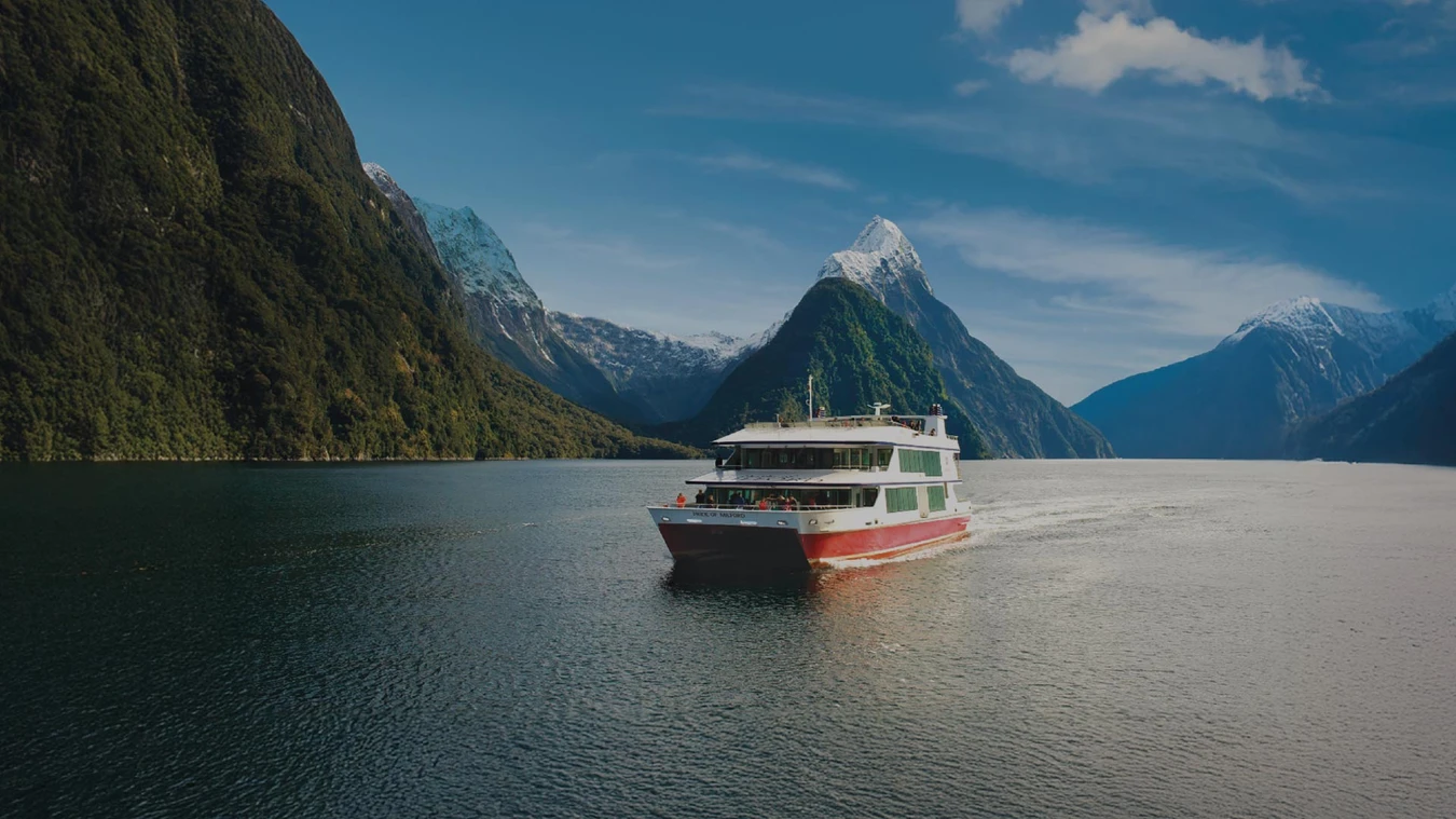 Boat cruising through Milford Sound in New Zealand