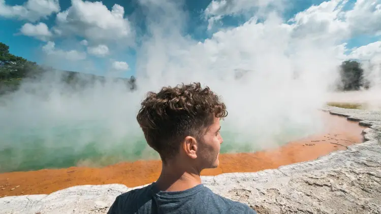 Man standing in front of the Champagne Pool in Rotorua