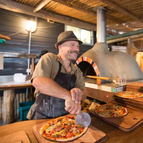 Chef cutting a pizza at Luke's Kitchen