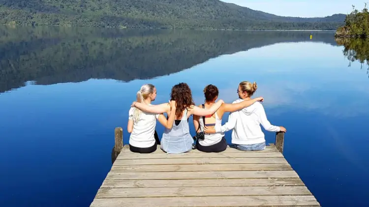 Group of friends hugging on a pier in New Zealand