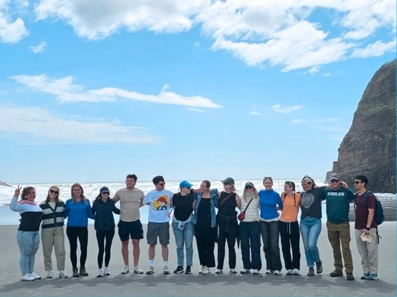 Wild Kiwi group exploring a remote New Zealand beach on a small-group adventure tour, enjoying coastal scenery in a relaxed and safe setting.
