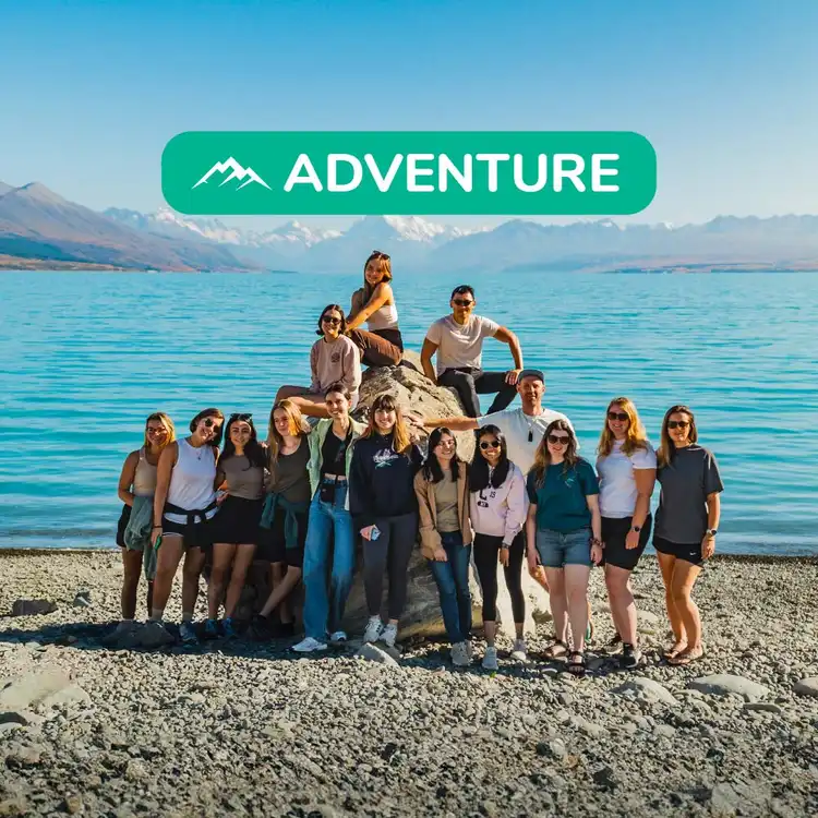Group of people pose for a photo in front of Lake Tekapo in New Zealand