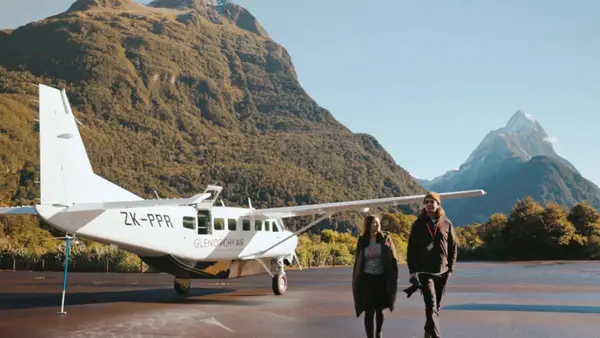 Couple walking away from plane on the runway at Milford Sound