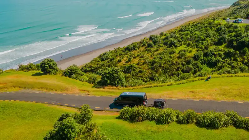 Wild Kiwi bus driving on the coast of Raglan