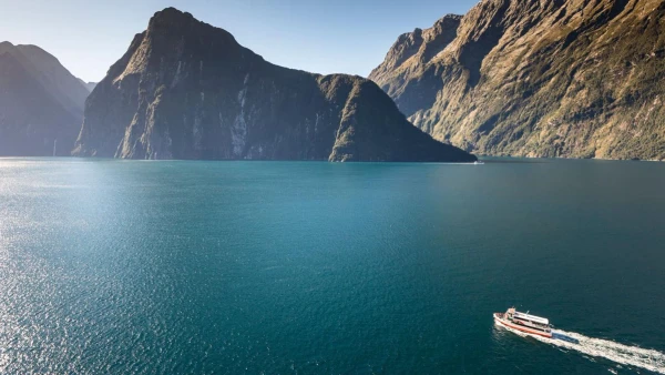 Boat cruising through Milford Sound