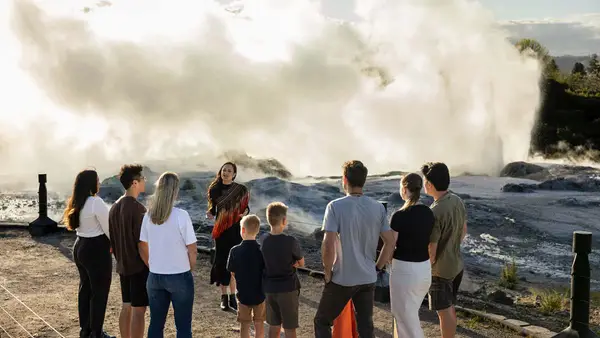 Group of people getting a guided tour in front of a geyser at Te Puia