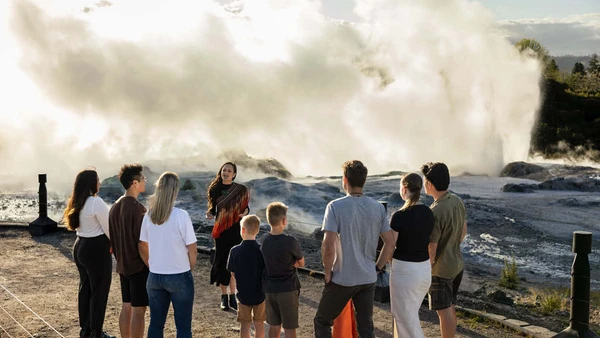 Group of people getting a guided tour in front of a geyser at Te Puia
