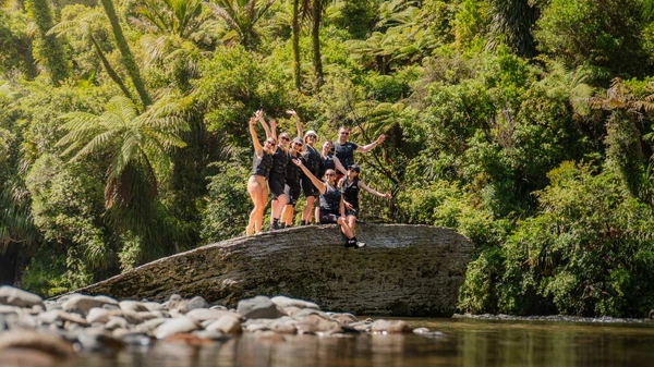 Group of people pose for a photo on a large rock