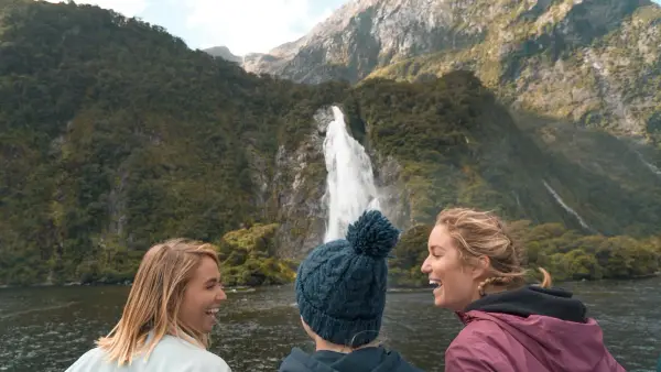 Three women look at at waterfall in Milford Sound