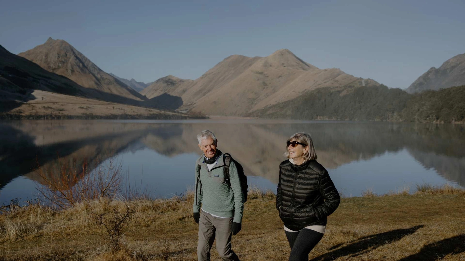 Couple walking along the shore of Moke Lake in Queenstown