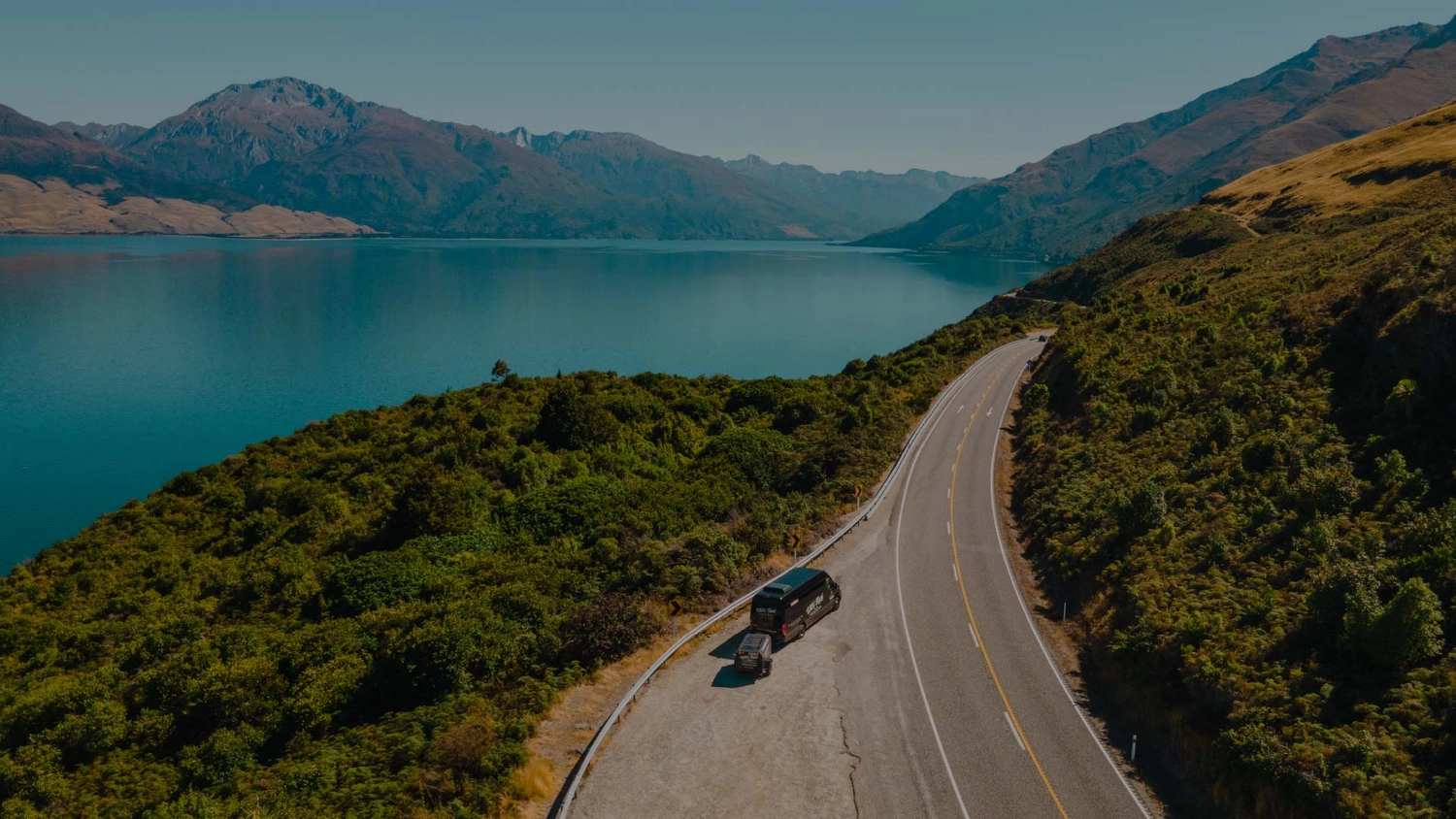 Wild Kiwi bus parked next to Lake Whakatipu in New Zealand